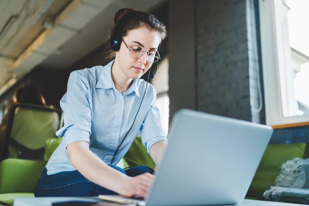 Female customer support phone operator working in modern office, accepting calls, consulting company clients.